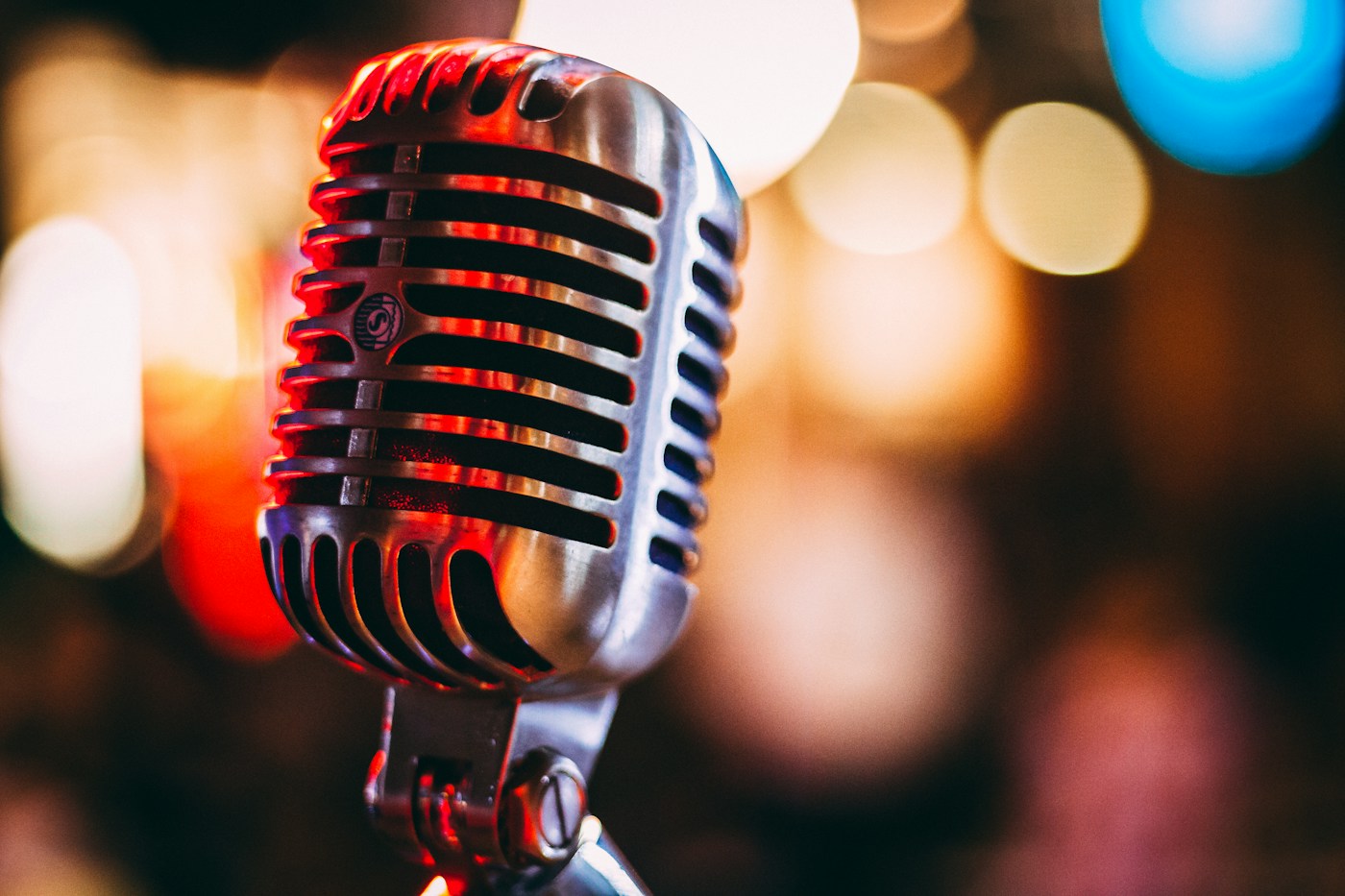 A vintage chrome microphone against warm bokeh lights