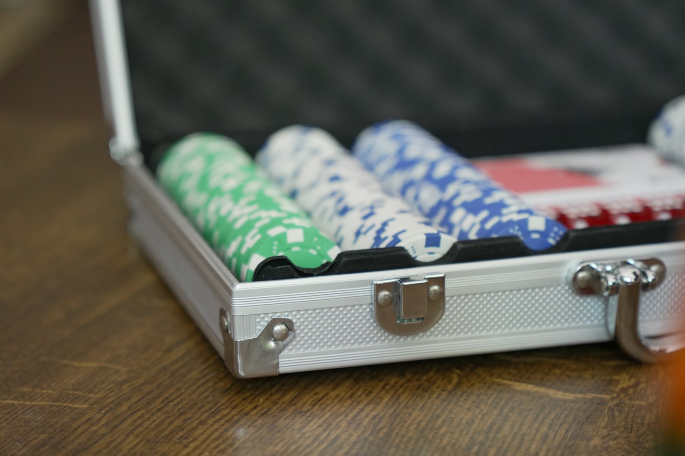 Poker chips in an open aluminium case on a wooden table